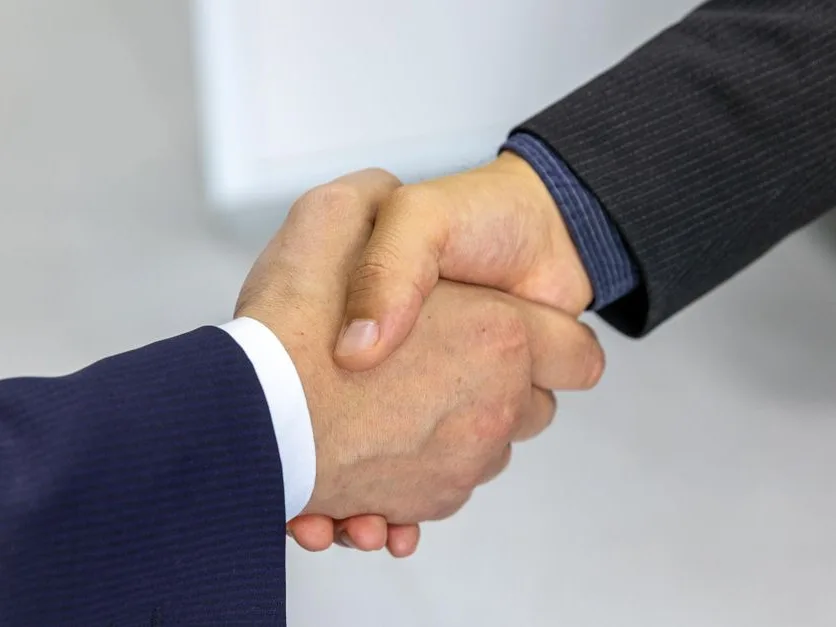 Deux personnes relisent un document de travail dans un bureau